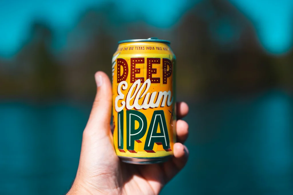 a person handle a can of IPA beer